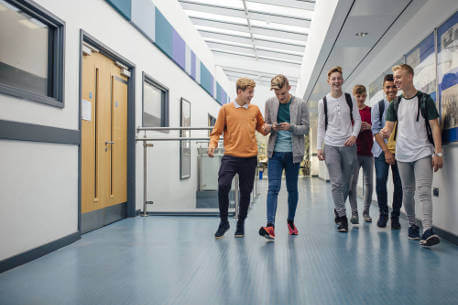 group-of-teens-walking-through-school-hallway