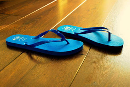 blue-flip-flops-on-wooden-floor